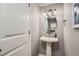 Small bathroom with pedestal sink and oval mirror at 6403 Zang Ct, Arvada, CO 80004