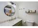 Green vanity and round mirror in this bathroom at 6403 Zang Ct, Arvada, CO 80004