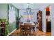 Light-filled dining room with hardwood floors and green accent wall at 6403 Zang Ct, Arvada, CO 80004