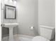 Elegant powder room with pedestal sink, framed mirror, and modern fixtures at 7606 S Valleyhead Ct, Aurora, CO 80016