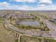 Aerial view of a community with a pond and nearby highway showcasing the surrounding landscape at 14710 Domino Dr, Parker, CO 80134