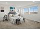 Bright bedroom with carpet, large windows, stylish gray headboard and bench, and artistic blue wall decor at 14710 Domino Dr, Parker, CO 80134