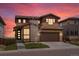 Beautiful two-story home with a two car garage, stone accents, manicured lawn and colorful sunset sky at 14710 Domino Dr, Parker, CO 80134