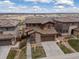 Beautiful two-story home with a stone facade, well-manicured lawn, and a two-car garage at 14710 Domino Dr, Parker, CO 80134