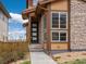 Modern front entry with stone and wood trim, and a concrete walkway at 14710 Domino Dr, Parker, CO 80134