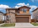 Charming two-story home featuring a stone facade, attached garage, and a well-maintained front lawn at 14710 Domino Dr, Parker, CO 80134