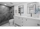A modern bathroom featuring dual sinks, sleek fixtures, and a stylish tiled shower with a glass door at 9230 Aspen Dr, Thornton, CO 80229