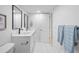 Well-lit bathroom with modern vanity, double sinks, tile floors, and convenient towel storage at 9230 Aspen Dr, Thornton, CO 80229