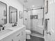 Modern bathroom with double sinks, sleek black fixtures, and a glass-enclosed shower featuring stunning marble-like tiles at 9230 Aspen Dr, Thornton, CO 80229