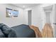 Bright bedroom features a window, a sliding closet door, and access to hallway at 9230 Aspen Dr, Thornton, CO 80229
