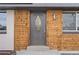 Close-up of a beautifully detailed front door with wood paneling, decorative glass, and contemporary lighting fixtures at 9230 Aspen Dr, Thornton, CO 80229