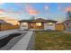 Charming home with updated white brick, wooden features, and a well-maintained front yard, complemented by a colorful sunset sky at 9230 Aspen Dr, Thornton, CO 80229