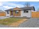 Stylish home with white brick, wooden accent, and landscaped front yard, presenting a welcoming and updated curb appeal at 9230 Aspen Dr, Thornton, CO 80229