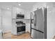 This kitchen features modern appliances including a stainless steel refrigerator and gas range stove with quartz countertops at 9230 Aspen Dr, Thornton, CO 80229