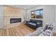 Inviting living room with wood floors, a modern fireplace, and ample natural light from a window at 9230 Aspen Dr, Thornton, CO 80229