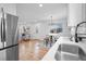 Open concept living and dining area adjacent to a modern kitchen with stainless steel appliances and hardwood floors at 9230 Aspen Dr, Thornton, CO 80229