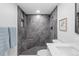 Luxurious tiled shower with a built-in bench, black fixtures, and elegant design at 9230 Aspen Dr, Thornton, CO 80229