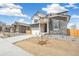 Charming two-story home featuring stone accents, white trim, a two-car garage, and professional landscaping at 6207 E 155Th Pl, Brighton, CO 80602