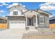 Charming two-story home featuring stone accents, white trim, a two-car garage, and professional landscaping at 6207 E 155Th Pl, Brighton, CO 80602