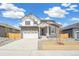 Charming two-story home boasts stone accents, a two-car garage, and a well-manicured front yard at 6207 E 155Th Pl, Brighton, CO 80602
