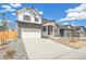Beautiful two-story home with stone and white siding, a two-car garage and inviting front porch at 6207 E 155Th Pl, Brighton, CO 80602