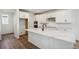Modern kitchen features an island with breakfast bar, stainless steel appliances, and white cabinets at 6207 E 155Th Pl, Brighton, CO 80602