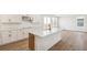 Bright kitchen with white cabinetry, stainless hood, and island with quartz countertop and sink at 6207 E 155Th Pl, Brighton, CO 80602