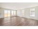 Bright, open-concept living room features wood floors and sliding door access to the backyard at 6207 E 155Th Pl, Brighton, CO 80602