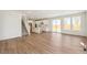 Bright, open-concept living room features wood floors, staircase and view to the modern kitchen at 6207 E 155Th Pl, Brighton, CO 80602