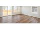 Bright, open-concept living room features wood floors and sliding door access to the fenced backyard at 6207 E 155Th Pl, Brighton, CO 80602