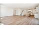 Bright, open-concept living room features wood floors, staircase, and view to the modern kitchen at 6207 E 155Th Pl, Brighton, CO 80602