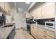 Bright kitchen featuring granite counters, tile floors, a microwave, and light wood cabinets at 777 N Washington St # 304, Denver, CO 80203