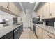 Modern kitchen with granite countertops, black cabinets, tile floors, and stainless steel appliances at 777 N Washington St # 304, Denver, CO 80203
