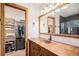 Bathroom featuring a rustic wooden vanity, vessel sink, and access to a walk-in closet and shower at 33844 Oriole Ct, Elizabeth, CO 80107