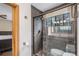 Bathroom featuring a tiled shower with glass enclosure and a wood-framed window letting in natural light at 33844 Oriole Ct, Elizabeth, CO 80107