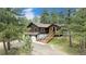 Scenic view of a charming two-story home nestled among tall pine trees at 33844 Oriole Ct, Elizabeth, CO 80107