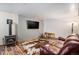 Inviting living room featuring a wood-burning stove, leather sofa, and a large screen television at 33844 Oriole Ct, Elizabeth, CO 80107