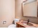 Cozy powder room with a rustic wooden vanity and sink, complemented by neutral wall color and fixtures at 33844 Oriole Ct, Elizabeth, CO 80107