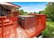 Backyard view features a large red deck with hot tub, outdoor seating, and barbeque at 6336 W 71St Pl, Arvada, CO 80003
