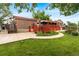 Exterior view of backyard featuring a large red deck and green grass and greenery at 6336 W 71St Pl, Arvada, CO 80003