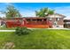 Exterior view of backyard featuring a large red deck and green grass and greenery at 6336 W 71St Pl, Arvada, CO 80003