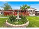 Beautiful backyard with fountain, landscaped flower beds, grassy area and a brick home with a deck at 6336 W 71St Pl, Arvada, CO 80003