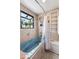 Relaxing bathroom featuring a deep soaking tub with jets, a unique window, and tiled walls at 6336 W 71St Pl, Arvada, CO 80003