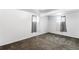 An empty room with plush carpeting features neutral walls and two windows covered with patterned sheer curtains at 6336 W 71St Pl, Arvada, CO 80003