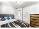 Bedroom with neutral gray headboard, black-and-gray stripped comforter, and wood dresser at 6336 W 71St Pl, Arvada, CO 80003