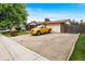 Wide driveway leading to a ranch-style home and garage, with a yellow truck parked at 6336 W 71St Pl, Arvada, CO 80003