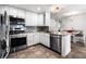 Modern kitchen with stainless steel appliances, granite counters and tile floors at 6336 W 71St Pl, Arvada, CO 80003