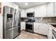 Well-equipped kitchen with stainless steel appliances, granite countertops and white cabinetry at 6336 W 71St Pl, Arvada, CO 80003