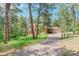 Charming home featuring a spacious deck, two-car garage, and a long driveway surrounded by lush trees and greenery at 1540 Fawnwood Rd, Monument, CO 80132