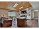 Spacious living room with hardwood floors, fireplace, built-in shelving, and skylights for natural light at 1540 Fawnwood Rd, Monument, CO 80132